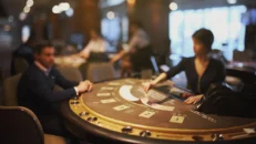 man in suit playing at a blackjack table